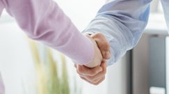 Eine junge Frau die einem Mann die Hand gibt