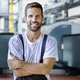 Ein Mann in Arbeitskleidung mit verschraenkten Armen