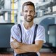 Ein Mann in Arbeitskleidung mit verschraenkten Armen